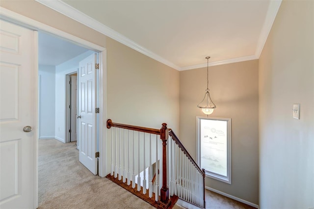 corridor featuring carpet flooring, crown molding, an upstairs landing, and baseboards