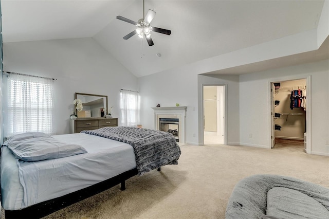 carpeted bedroom featuring a fireplace, baseboards, high vaulted ceiling, a spacious closet, and a ceiling fan