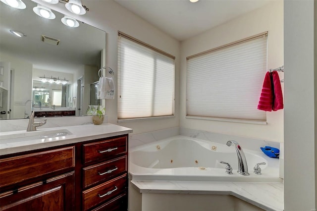 bathroom featuring vanity, a whirlpool tub, a stall shower, and visible vents