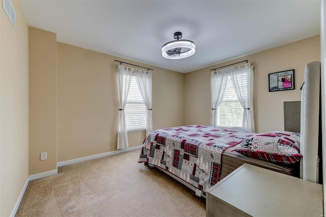 carpeted bedroom featuring baseboards and visible vents