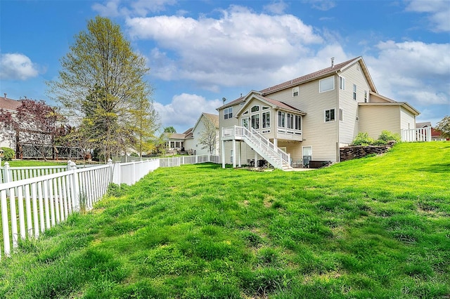 back of property featuring a fenced backyard, a lawn, stairs, and a sunroom