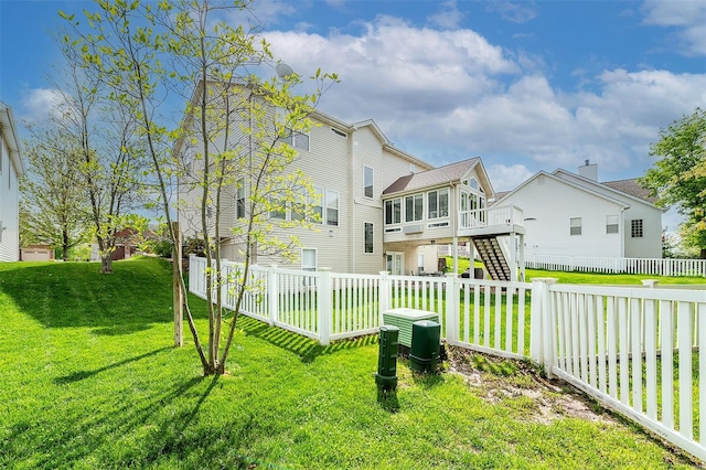 back of house featuring a wooden deck, a fenced backyard, stairs, a sunroom, and a lawn