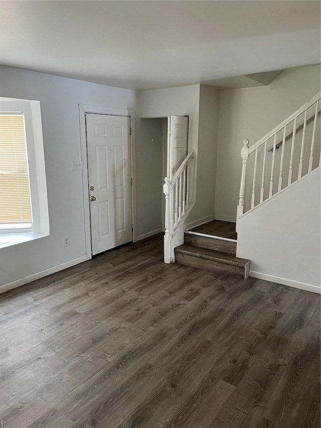 foyer entrance with baseboards, stairs, and wood finished floors