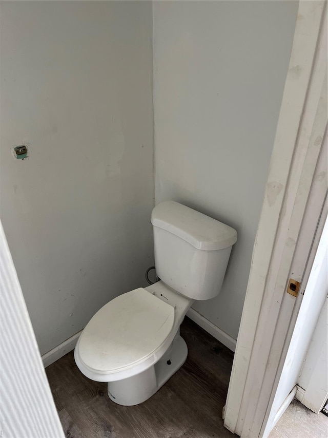 bathroom featuring toilet, baseboards, and wood finished floors