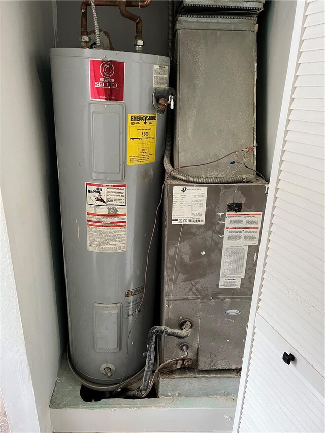 utility room featuring water heater and heating unit