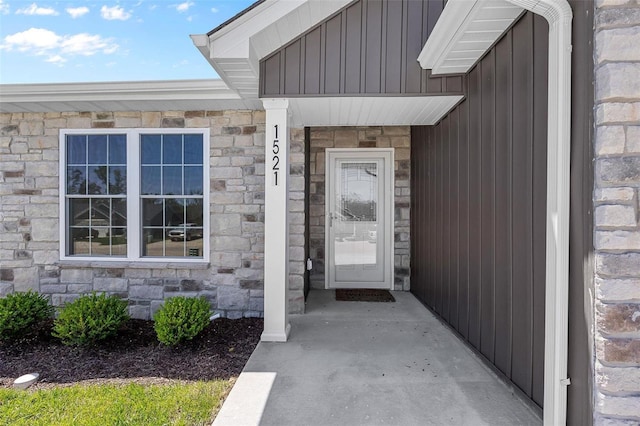 entrance to property featuring board and batten siding and stone siding