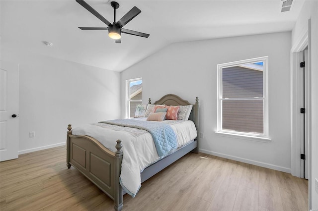 bedroom with baseboards, vaulted ceiling, light wood-type flooring, and visible vents