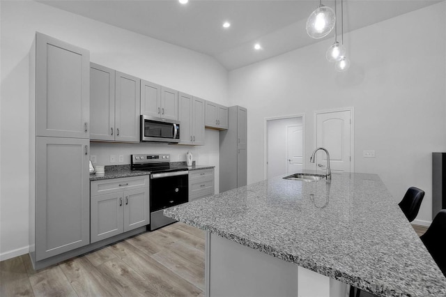 kitchen with high vaulted ceiling, light wood-type flooring, a sink, appliances with stainless steel finishes, and gray cabinetry
