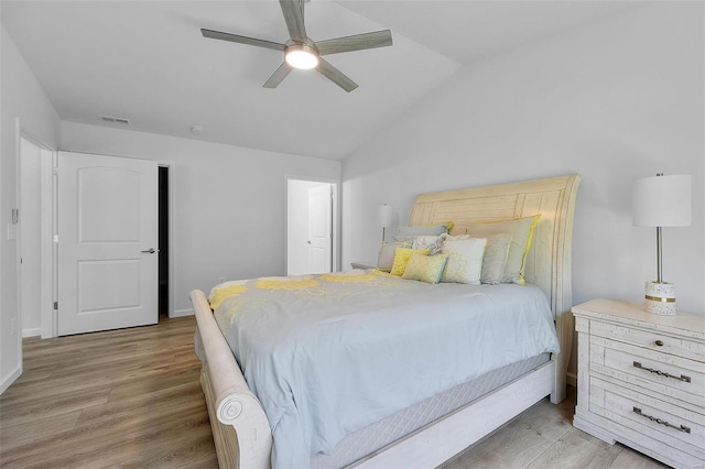 bedroom with visible vents, a ceiling fan, wood finished floors, and vaulted ceiling