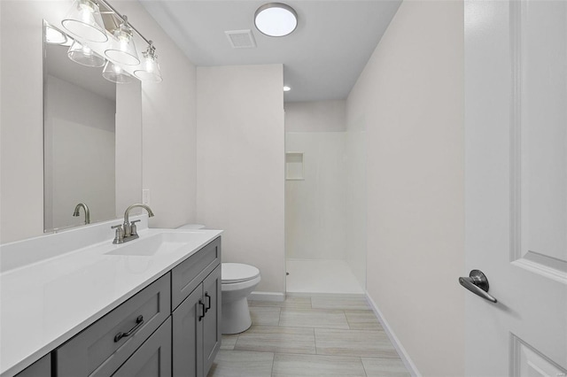 full bath featuring walk in shower, vanity, toilet, baseboards, and visible vents