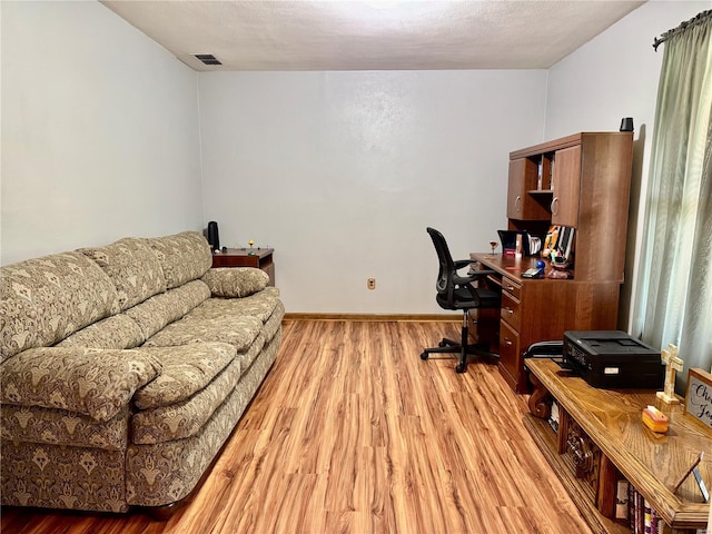 office with baseboards, visible vents, and light wood finished floors