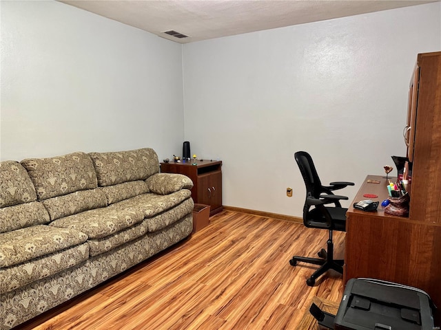 home office featuring light wood-style floors, baseboards, and visible vents