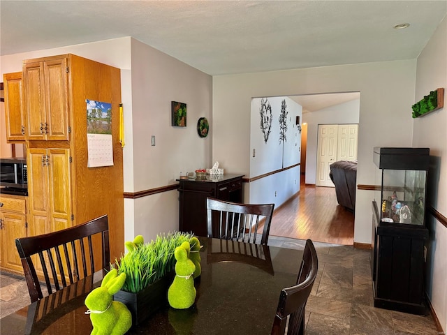 dining area with baseboards and stone tile flooring