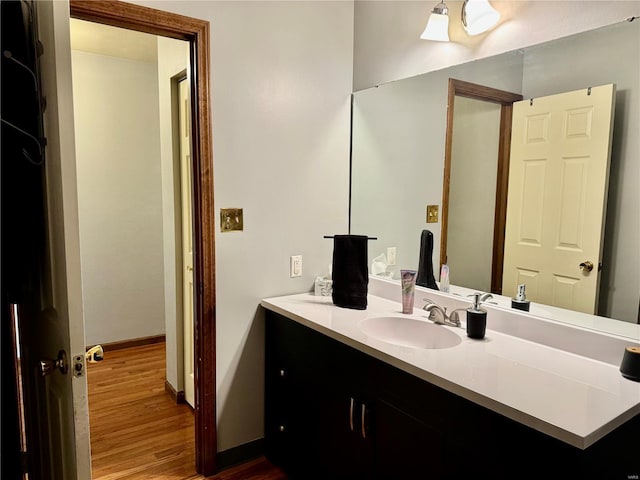 bathroom featuring baseboards, wood finished floors, and vanity