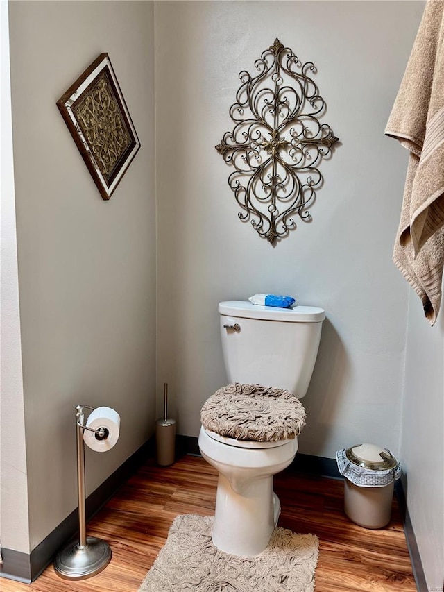 bathroom featuring baseboards, toilet, and wood finished floors