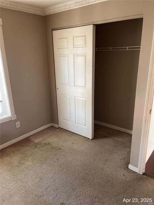unfurnished bedroom with carpet floors, baseboards, and a closet