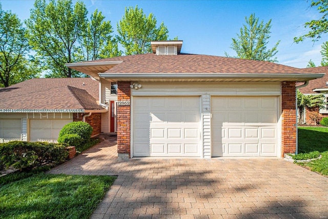 ranch-style house featuring roof with shingles, driveway, and brick siding
