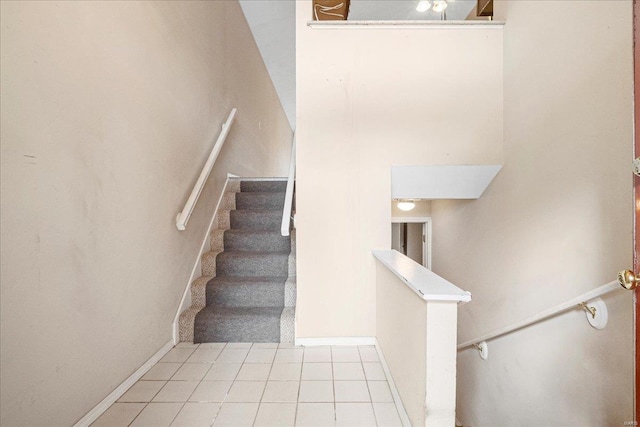 stairway featuring baseboards and tile patterned flooring
