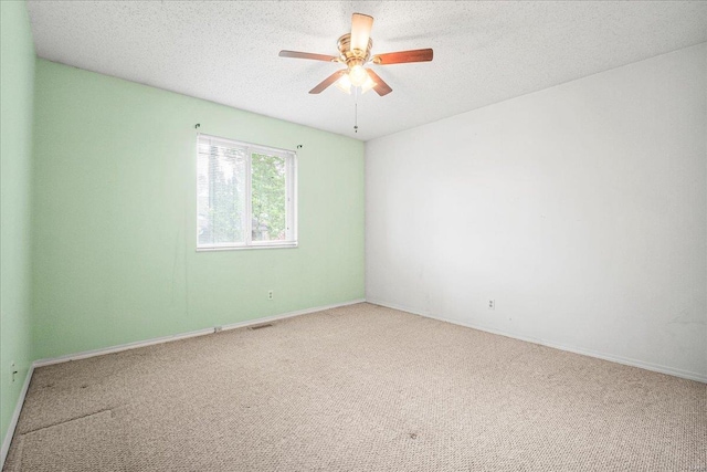 carpeted empty room featuring baseboards, a ceiling fan, a textured ceiling, and visible vents