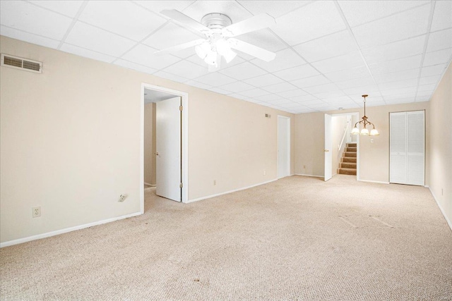 interior space featuring light carpet, a paneled ceiling, ceiling fan with notable chandelier, baseboards, and visible vents