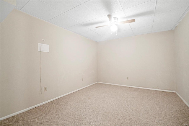 empty room featuring carpet flooring, ceiling fan, and a paneled ceiling