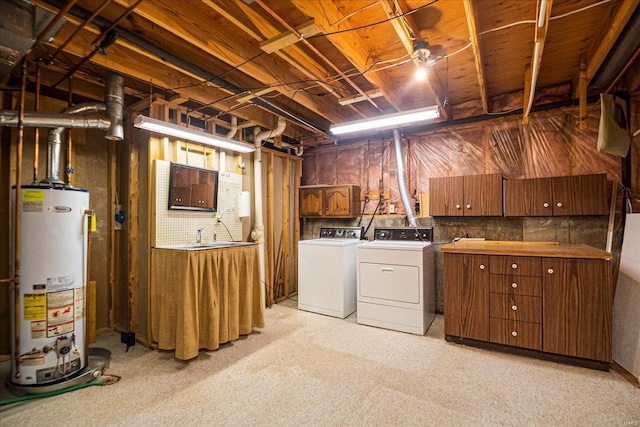 unfinished below grade area featuring washing machine and clothes dryer and gas water heater