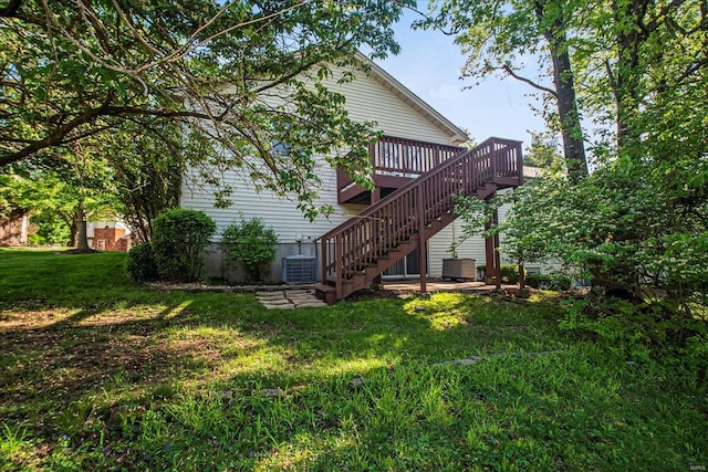 rear view of house with a wooden deck, a yard, central AC unit, and stairway