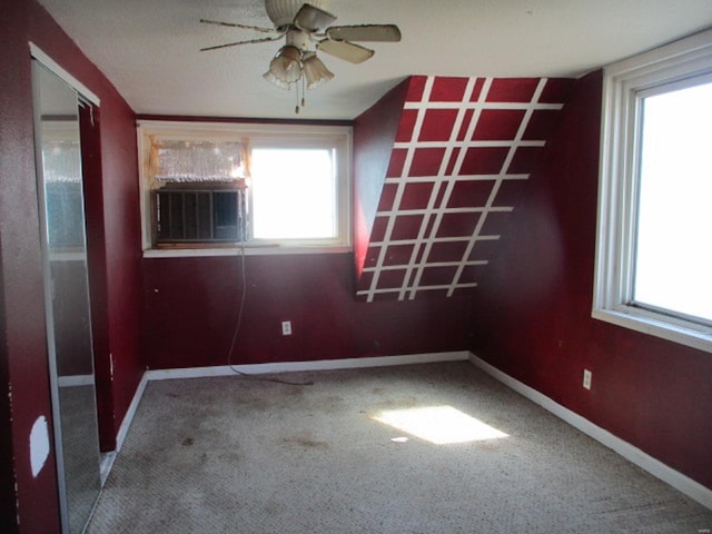 spare room with a ceiling fan, baseboards, plenty of natural light, and cooling unit