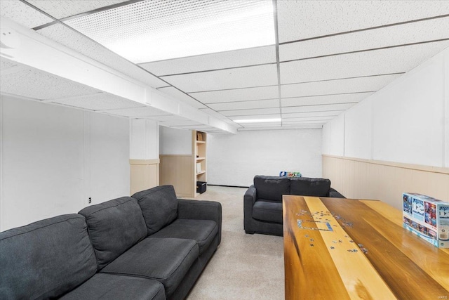living area with carpet flooring, wainscoting, and a paneled ceiling