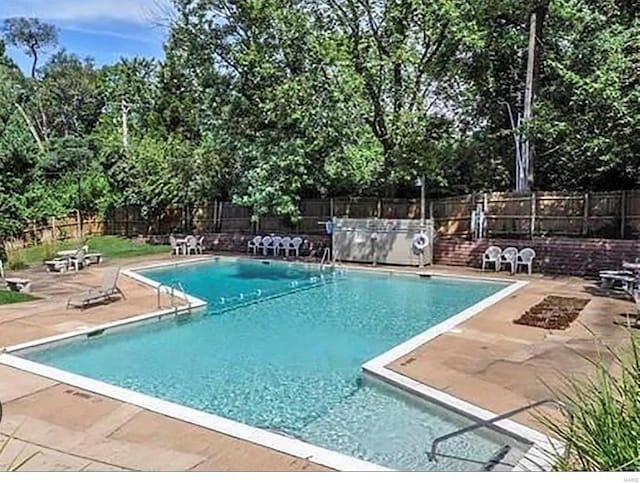 pool with a patio and a fenced backyard