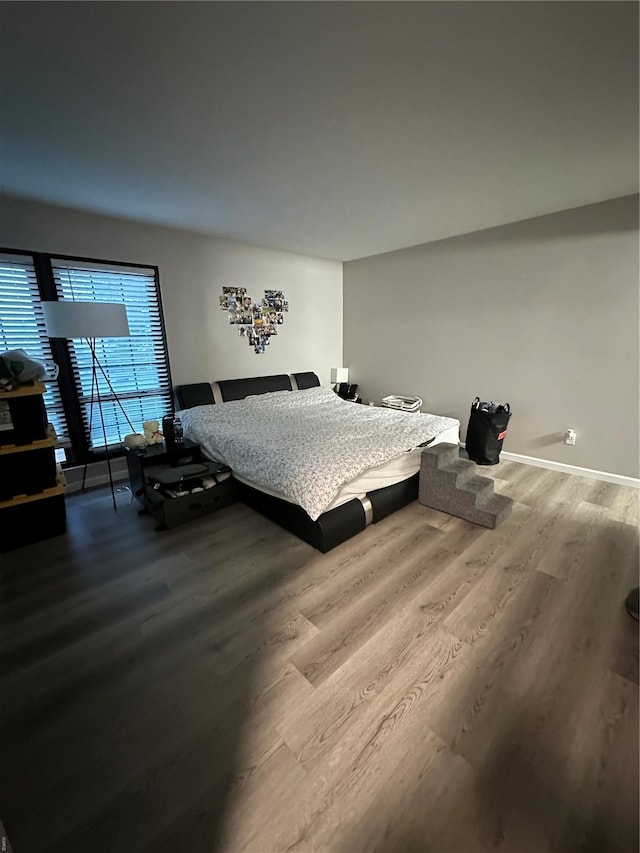 bedroom featuring baseboards and wood finished floors