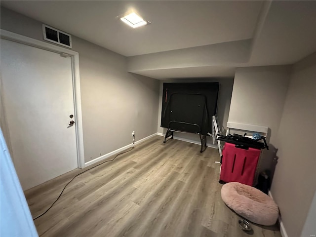 interior space with baseboards, visible vents, and light wood finished floors