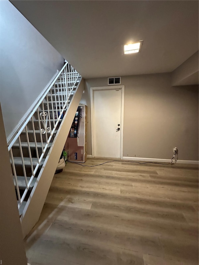 interior space featuring stairs, baseboards, visible vents, and wood finished floors