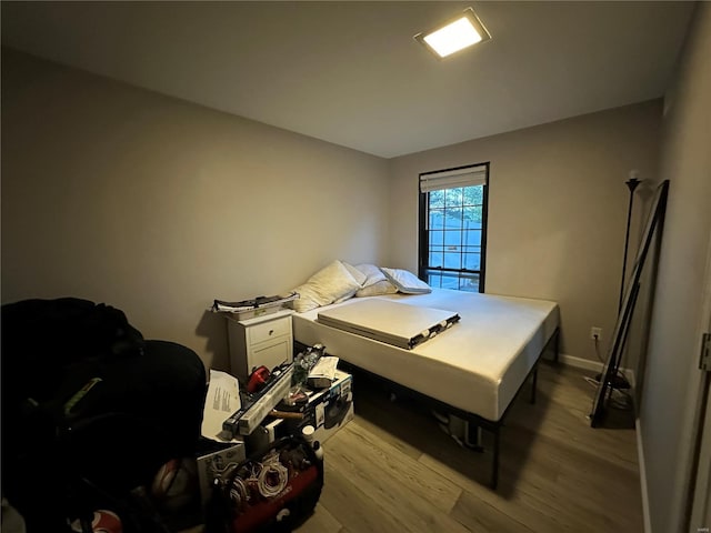 bedroom with baseboards and light wood finished floors