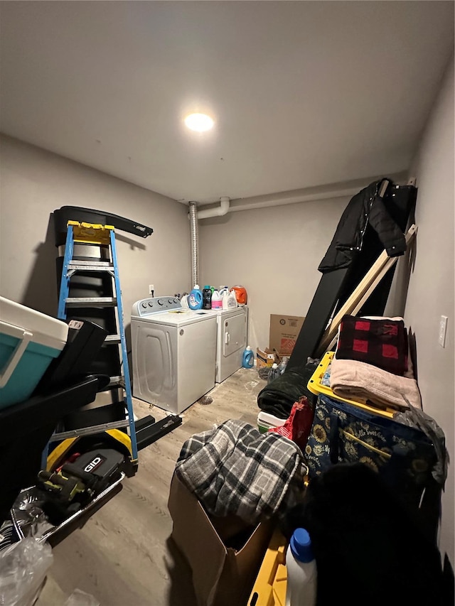 laundry area featuring separate washer and dryer, laundry area, and wood finished floors
