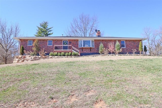 single story home with brick siding, a front lawn, and a chimney