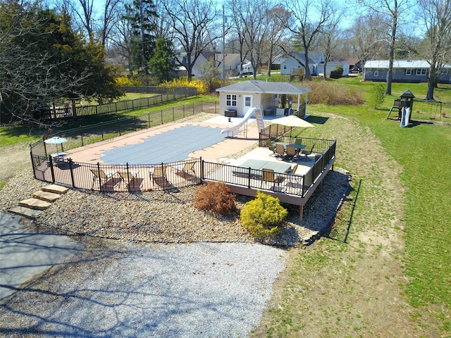 view of swimming pool featuring fence, a water slide, a fenced in pool, a lawn, and a patio