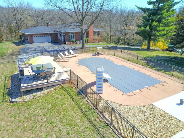 view of pool with a lawn, fence, and outdoor dining space