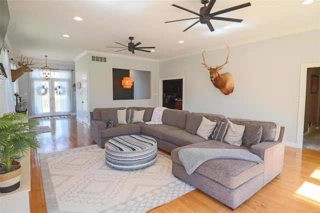 living area featuring french doors, visible vents, crown molding, wood finished floors, and recessed lighting