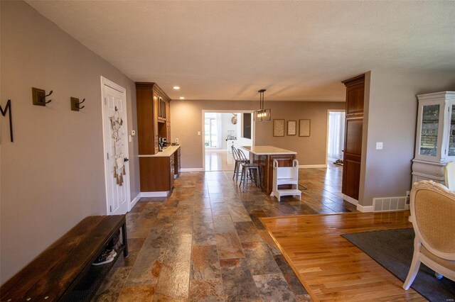 interior space with baseboards, visible vents, and stone finish floor