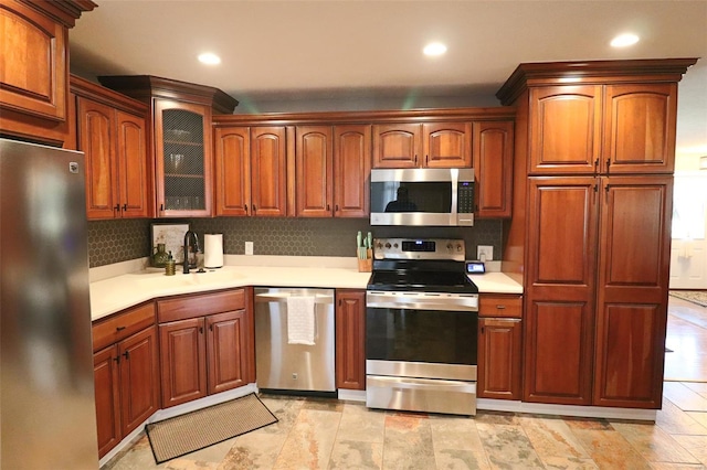 kitchen featuring light countertops, backsplash, stainless steel appliances, and recessed lighting