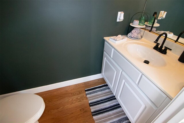 bathroom with vanity, baseboards, and wood finished floors