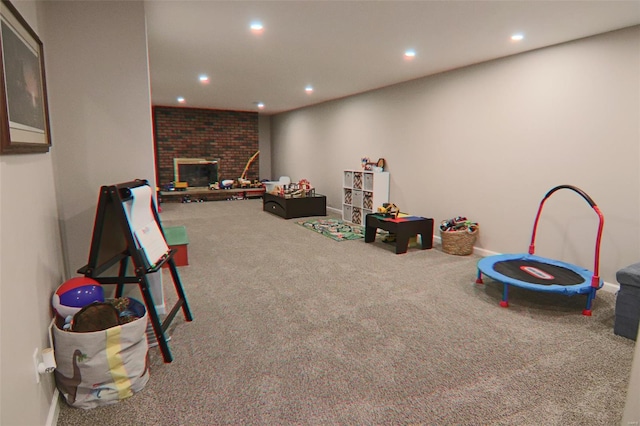 rec room featuring a fireplace, baseboards, carpet, and recessed lighting