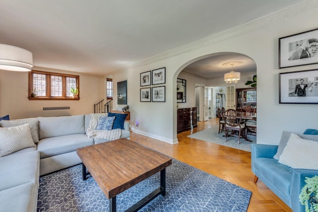 living room featuring baseboards, arched walkways, stairway, and ornamental molding