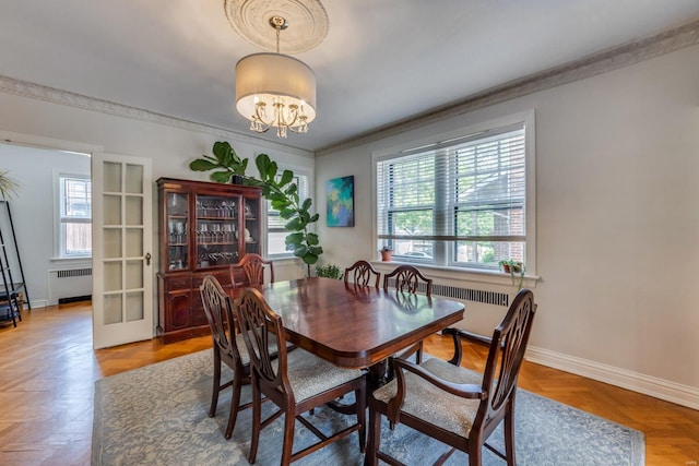 dining area featuring crown molding, radiator, baseboards, and a chandelier