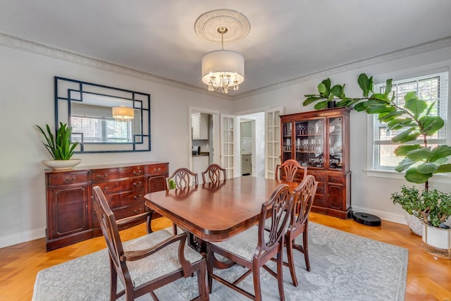 dining room featuring crown molding, baseboards, and a notable chandelier