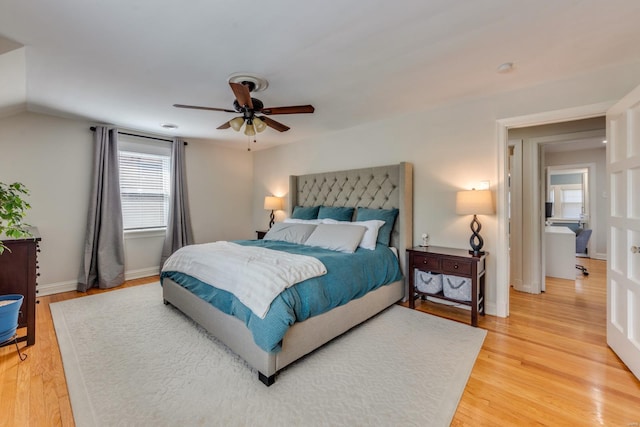 bedroom featuring a ceiling fan, baseboards, lofted ceiling, and light wood-style floors