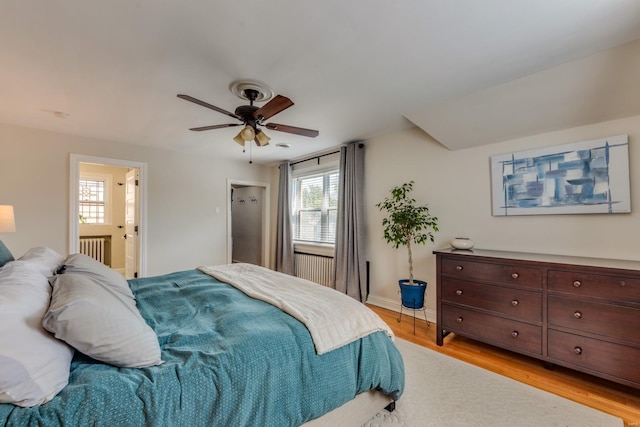 bedroom with light wood-style floors, connected bathroom, baseboards, and ceiling fan