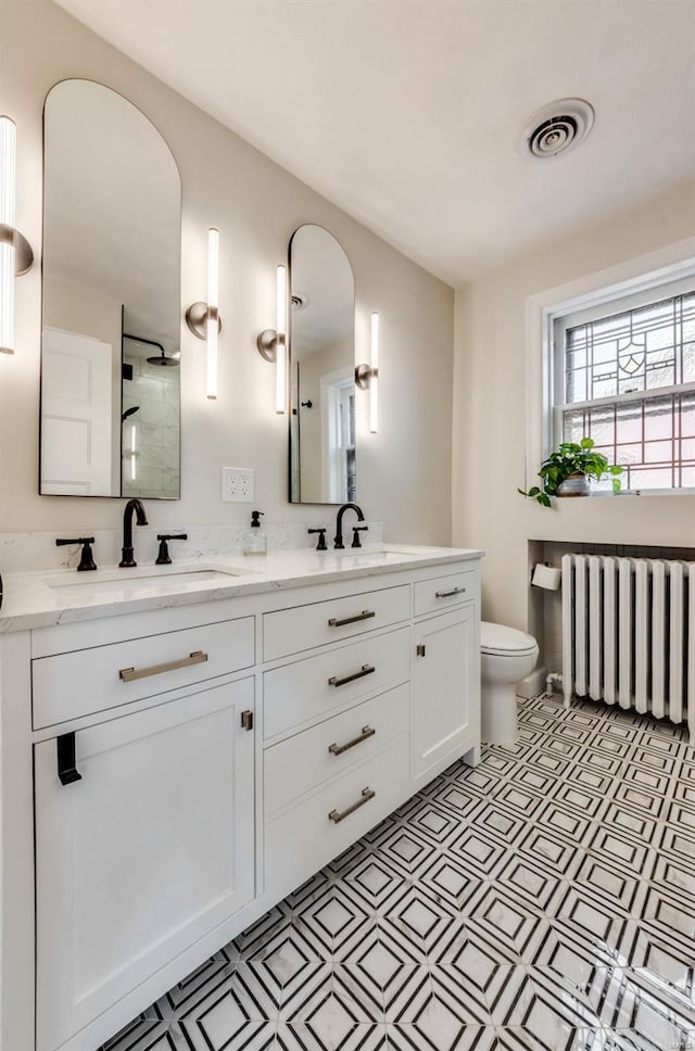bathroom with visible vents, a sink, radiator, and tile patterned floors