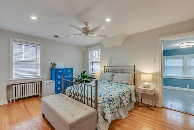 bedroom featuring radiator heating unit, baseboards, recessed lighting, and wood finished floors